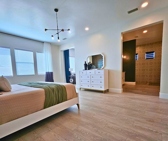 bedroom featuring light wood finished floors, visible vents, and baseboards