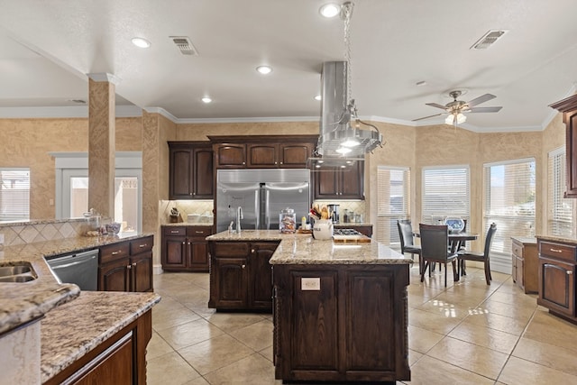 kitchen featuring a center island, hanging light fixtures, ceiling fan, dark brown cabinetry, and stainless steel appliances