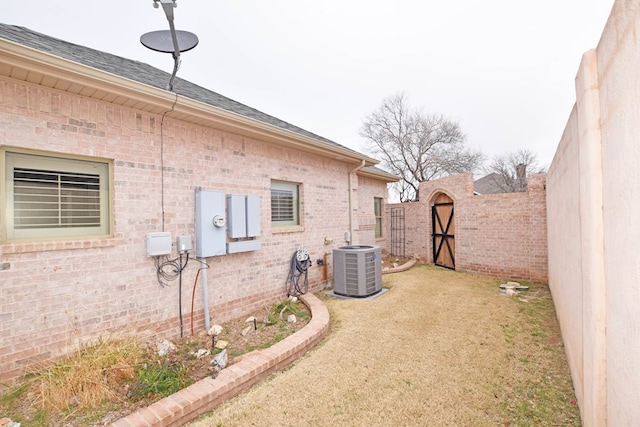 view of side of home featuring a yard and central AC unit