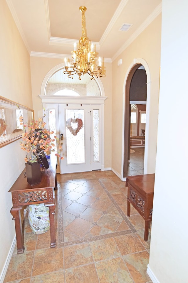 foyer featuring ornamental molding, a notable chandelier, and a tray ceiling