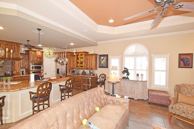 living room featuring sink, ornamental molding, a tray ceiling, ceiling fan, and tile patterned flooring