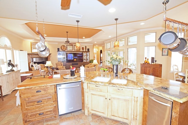 kitchen featuring a kitchen island with sink, sink, a tray ceiling, and stainless steel dishwasher