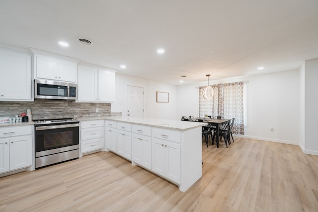 kitchen featuring kitchen peninsula, white cabinetry, and stainless steel appliances