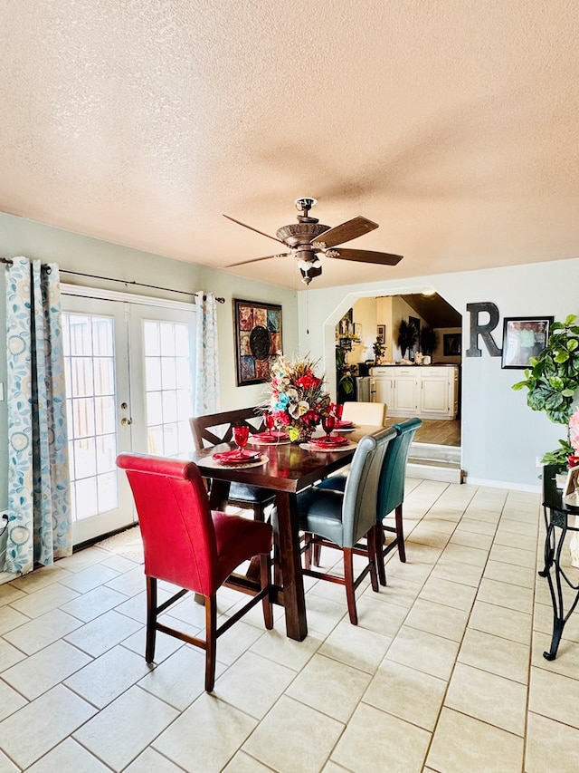 dining room featuring light tile patterned floors, french doors, a textured ceiling, and a ceiling fan