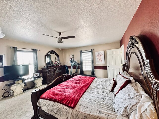 bedroom with multiple windows, carpet floors, a textured ceiling, and ceiling fan