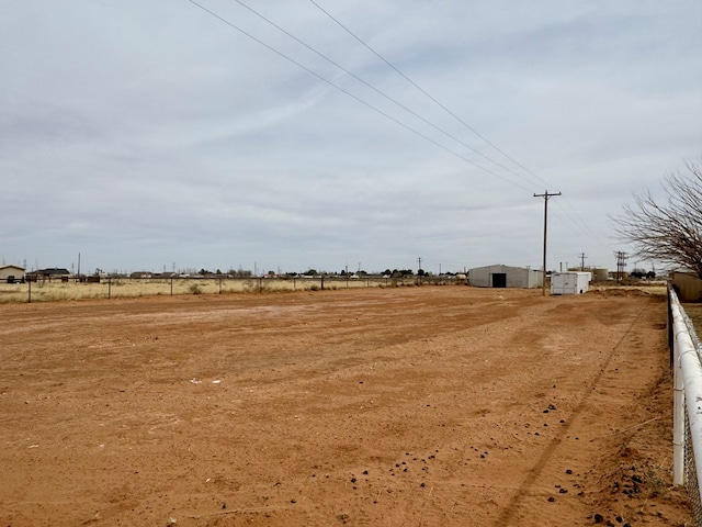 view of yard with a rural view and an outdoor structure