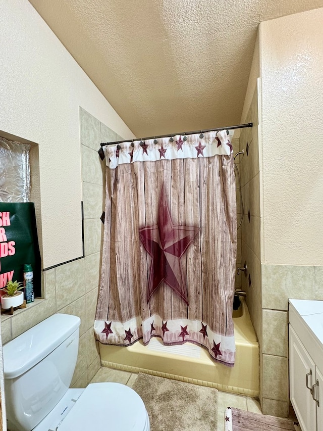 full bathroom with tile walls, toilet, vanity, a textured ceiling, and shower / bathtub combination with curtain