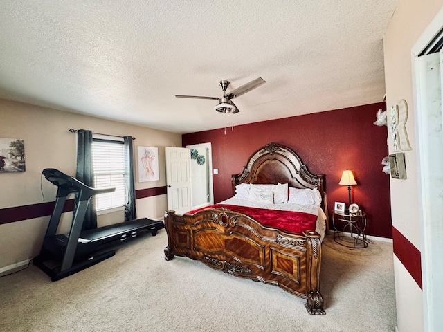 carpeted bedroom featuring a textured ceiling and a ceiling fan