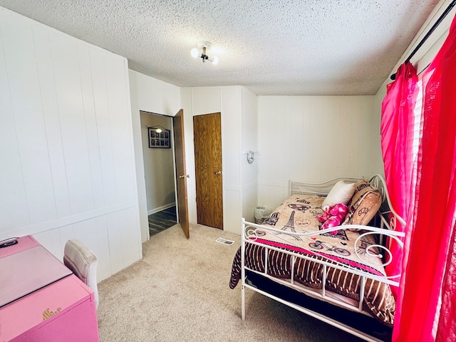 carpeted bedroom with visible vents and a textured ceiling