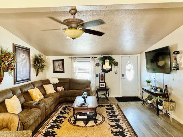 living area with wood finished floors, baseboards, lofted ceiling, ceiling fan, and a textured ceiling