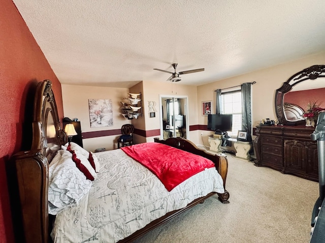 bedroom with a textured ceiling, carpet floors, and ceiling fan