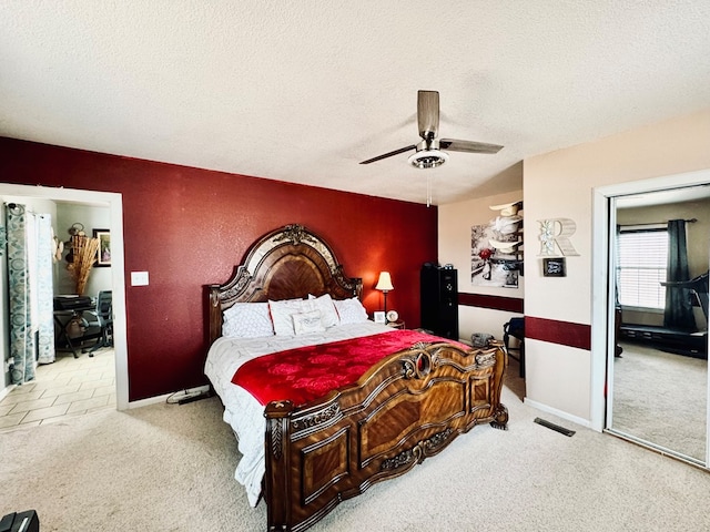 bedroom featuring a ceiling fan, a textured ceiling, and carpet flooring