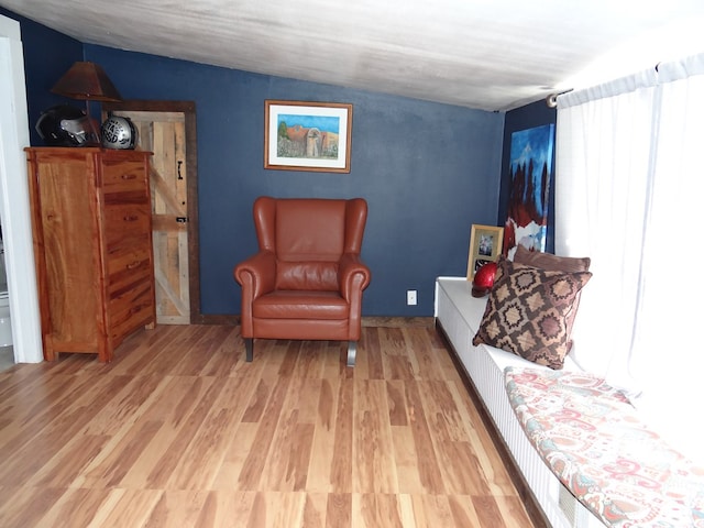 living area featuring lofted ceiling and light wood-type flooring