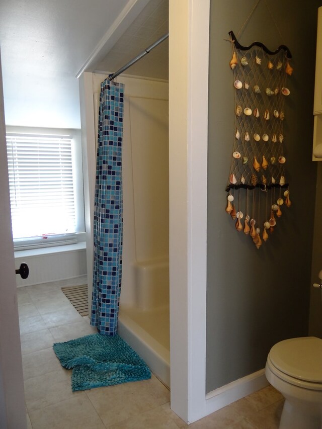 bathroom with toilet, tile patterned floors, and curtained shower