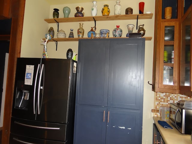 kitchen with backsplash, blue cabinets, and stainless steel appliances