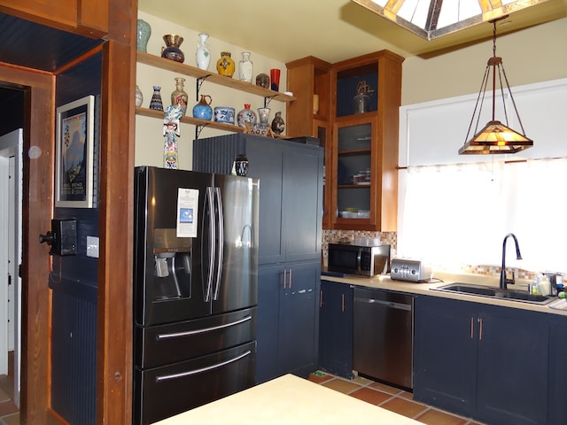 kitchen featuring pendant lighting, backsplash, blue cabinets, sink, and stainless steel appliances