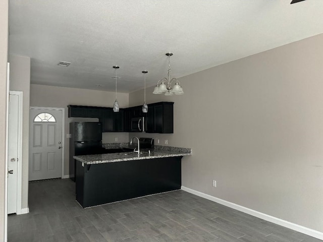 kitchen with kitchen peninsula, light stone countertops, dark wood-type flooring, black appliances, and decorative light fixtures