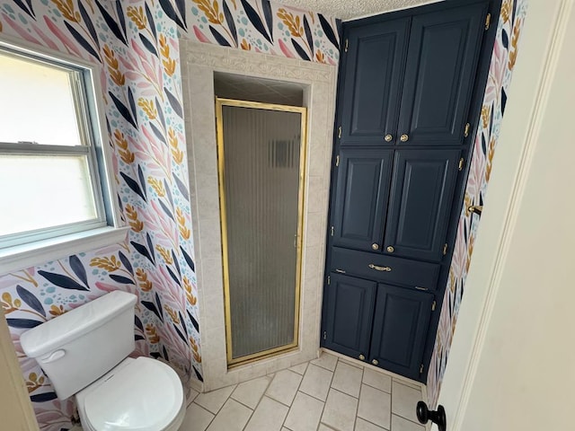 bathroom with toilet, tile patterned floors, and a shower with shower door