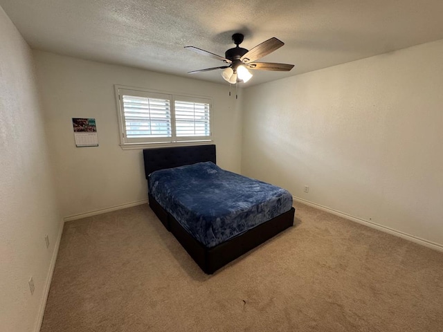 bedroom with ceiling fan, carpet, and a textured ceiling