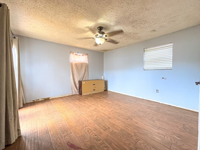 unfurnished room featuring hardwood / wood-style floors, ceiling fan, and a textured ceiling