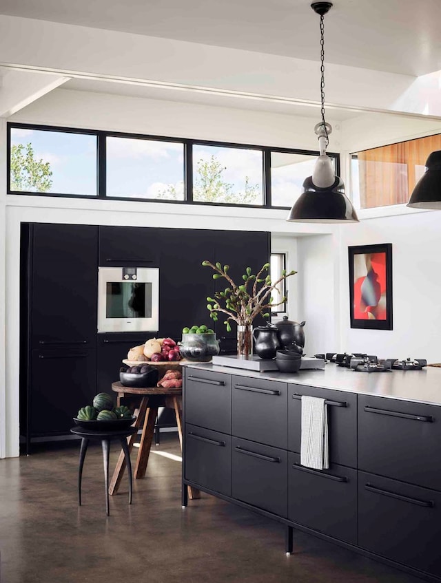 bar with decorative light fixtures, gray cabinets, white gas stovetop, and a healthy amount of sunlight