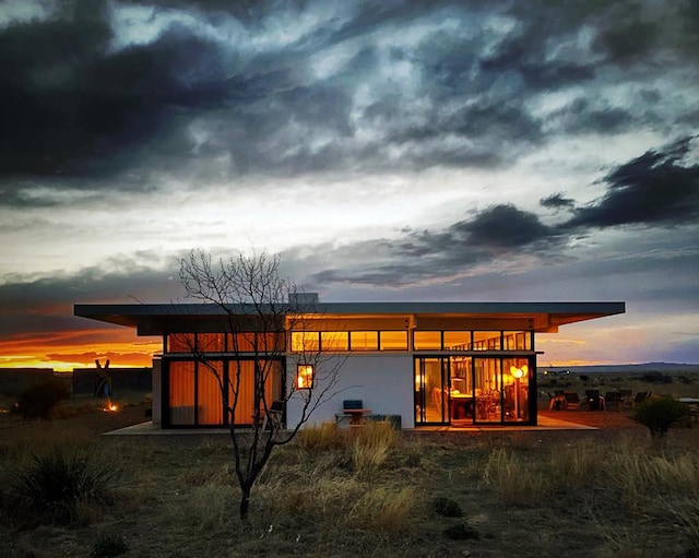 view of back house at dusk