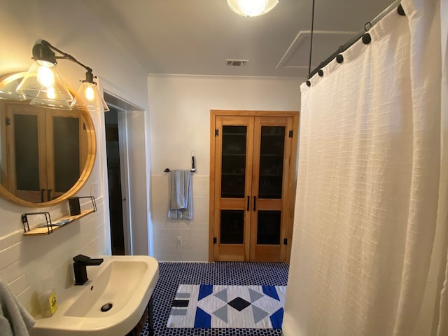 bathroom featuring tile patterned floors, sink, and tile walls