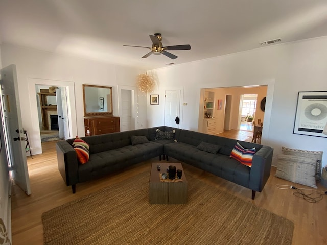 living room featuring light wood-type flooring and ceiling fan