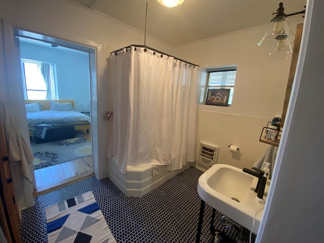 bathroom with tile patterned flooring, shower / bath combination with curtain, and sink