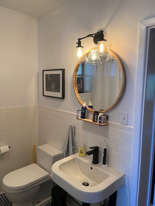 bathroom featuring toilet, tile walls, crown molding, and sink