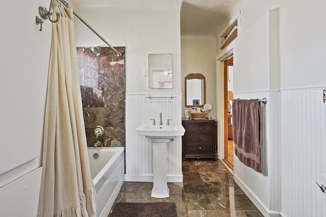 bathroom featuring shower / bath combo, marble finish floor, and wainscoting