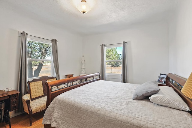 bedroom featuring a textured ceiling and wood finished floors