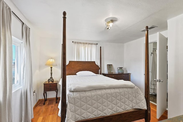 bedroom with light wood-type flooring, multiple windows, and visible vents