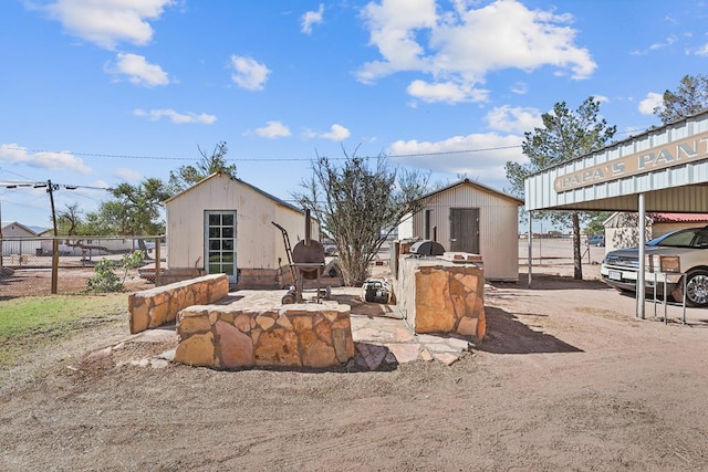 exterior space with an outbuilding, a carport, and fence