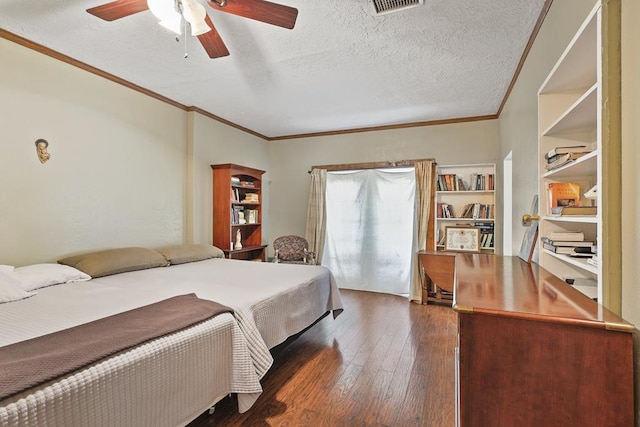 bedroom with dark wood-style floors, crown molding, visible vents, ceiling fan, and a textured ceiling