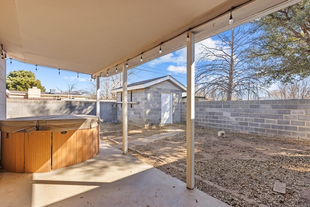 view of patio featuring a hot tub and a shed