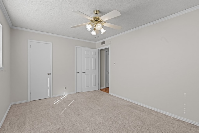 unfurnished bedroom with ornamental molding, light colored carpet, and a textured ceiling