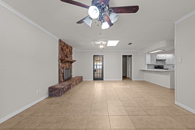 unfurnished living room featuring crown molding, ceiling fan, a fireplace, and light tile patterned floors