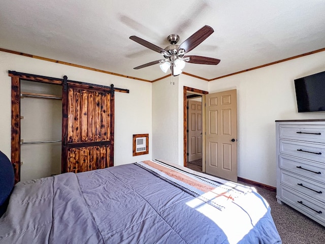 carpeted bedroom with ornamental molding, heating unit, a barn door, baseboards, and ceiling fan