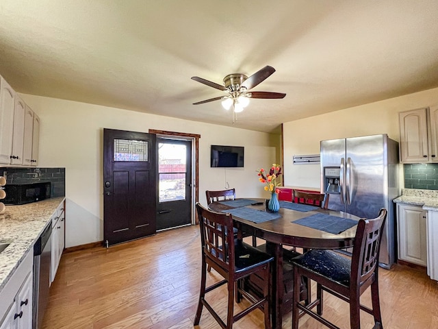 dining space with a ceiling fan, light wood-type flooring, and baseboards