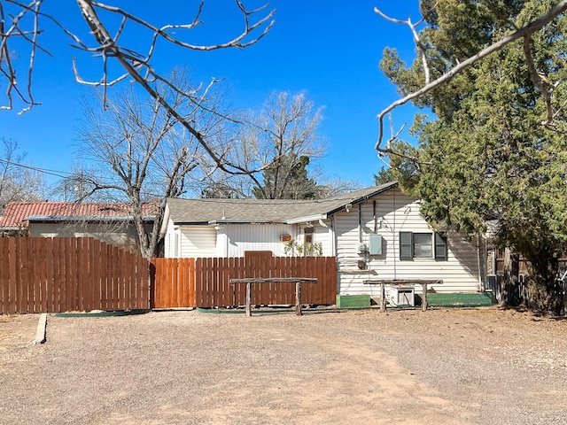 view of front facade featuring fence and a shingled roof