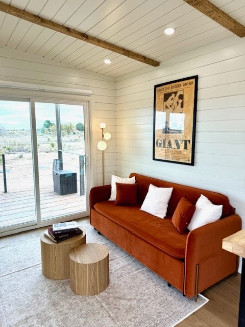 living room with wood ceiling, beamed ceiling, and wood finished floors