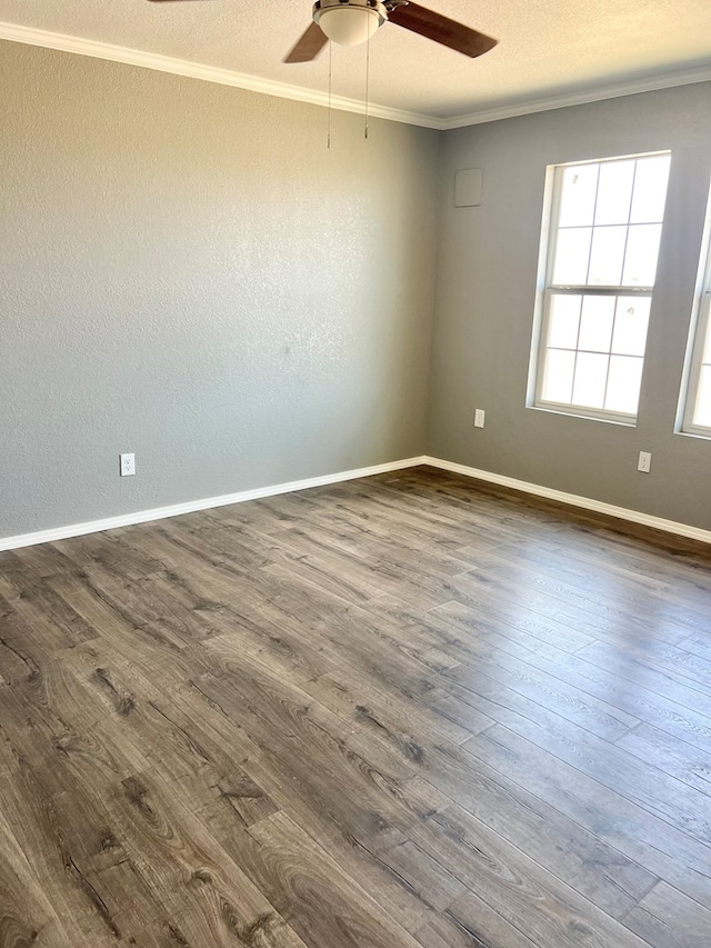 empty room with ceiling fan, dark hardwood / wood-style flooring, and crown molding