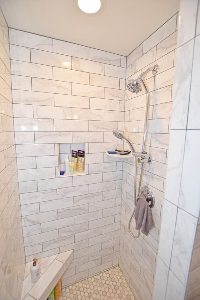 bathroom with tile patterned flooring and tiled shower