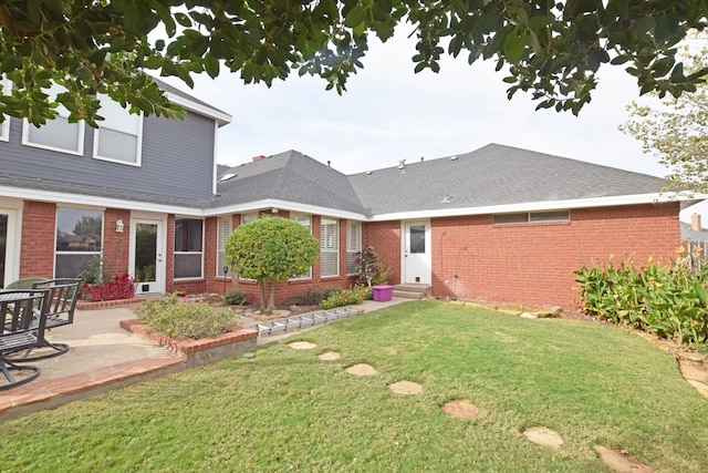 back of house with a yard and a patio