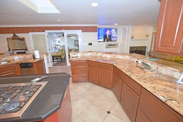 kitchen with ceiling fan, light stone countertops, crown molding, stainless steel gas stovetop, and light tile patterned flooring