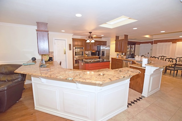 kitchen featuring a large island, a kitchen breakfast bar, kitchen peninsula, and appliances with stainless steel finishes