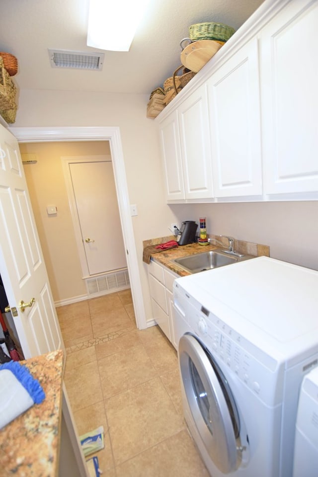 laundry room featuring washer and dryer, cabinets, light tile patterned floors, and sink