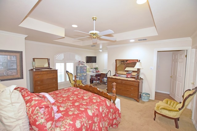 bedroom with ceiling fan, a raised ceiling, light colored carpet, and crown molding