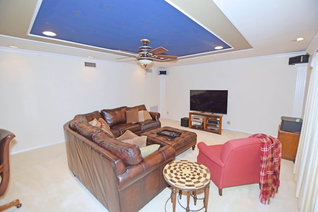 living room featuring carpet, decorative columns, a raised ceiling, and crown molding